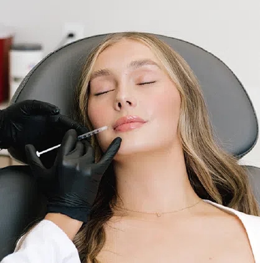 Woman receiving cosmetic treatment with syringe.