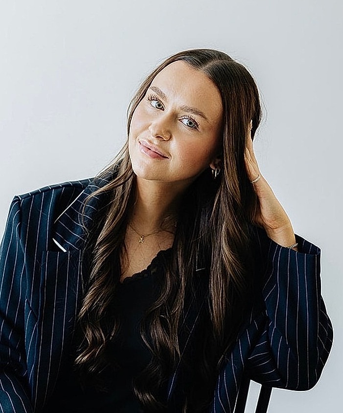 Woman in pinstripe blazer with long hair.