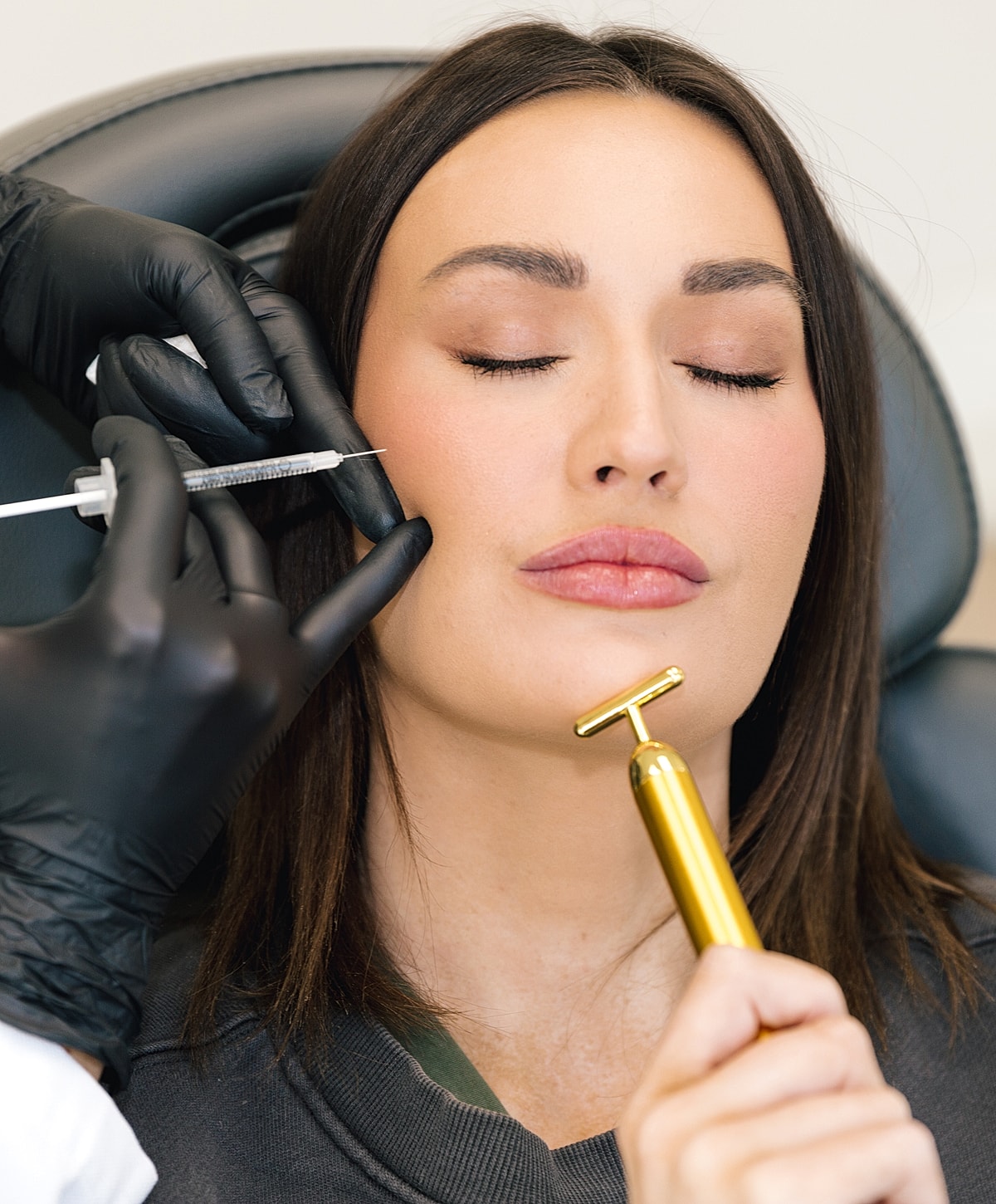 Injecting cosmetic treatment on a woman's face.