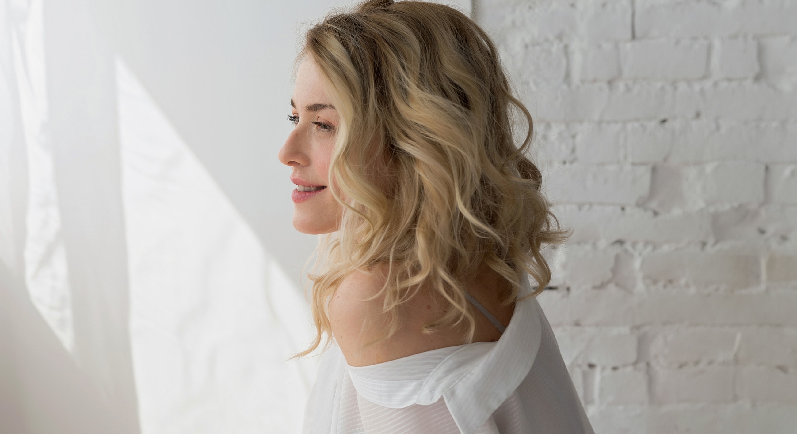 Woman with wavy hair against a white background.